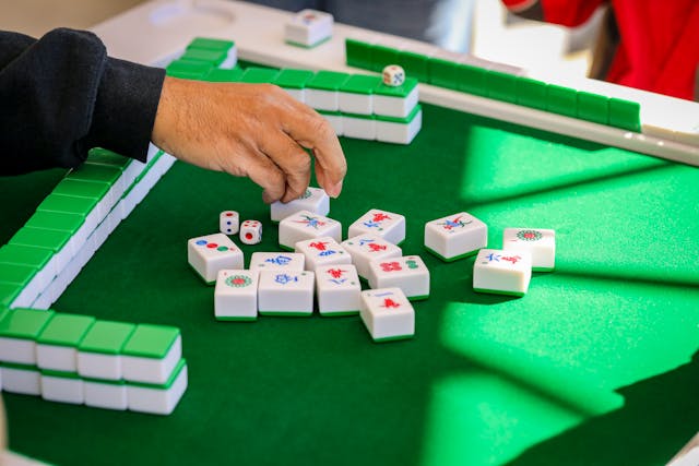 Spiller rækker ud efter mahjong-brikker