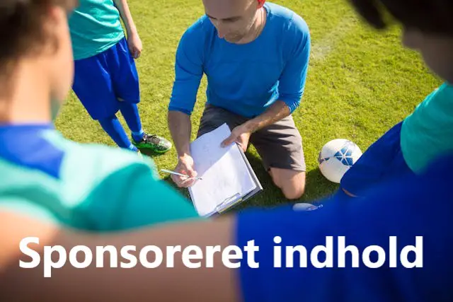 Træner viser spillere i rundkreds taktik nedfældet på stor notesblok